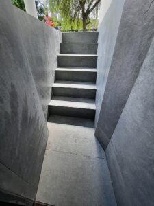 schody prowadzące poniżej poziomu gruntu wyłożone płytkami stopnie oraz ściany