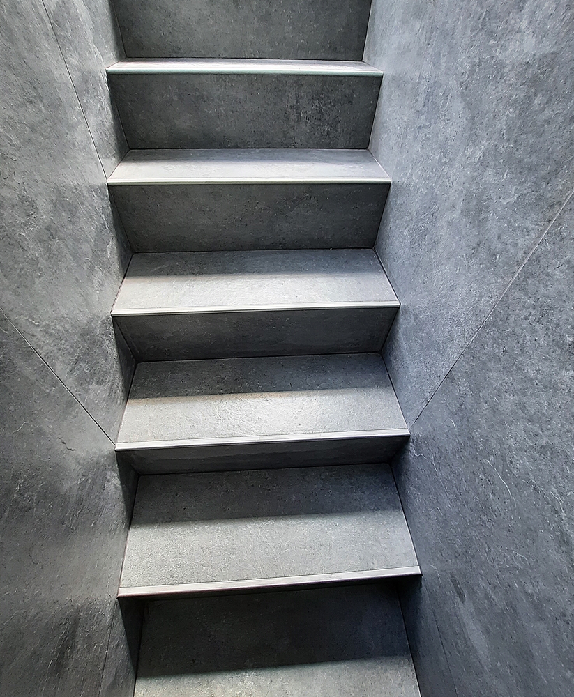 schody prowadzące poniżej poziomu gruntu wyłożone płytkami stopnie oraz ściany