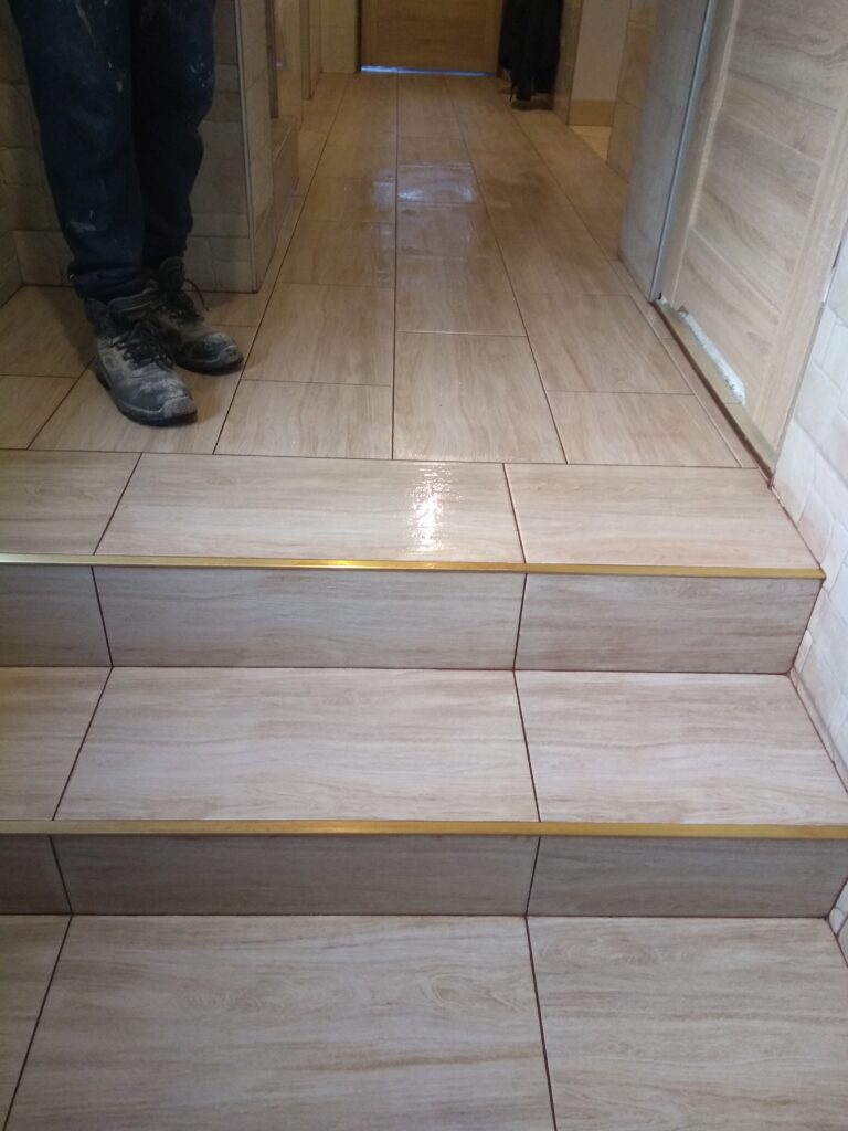 schody w domu wyłożone płytkami równo z podłogą